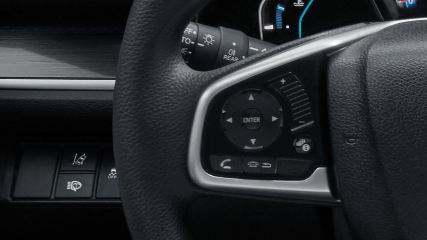 Detailní záběr ovládacích prvků informačního displeje řidiče na volantu.