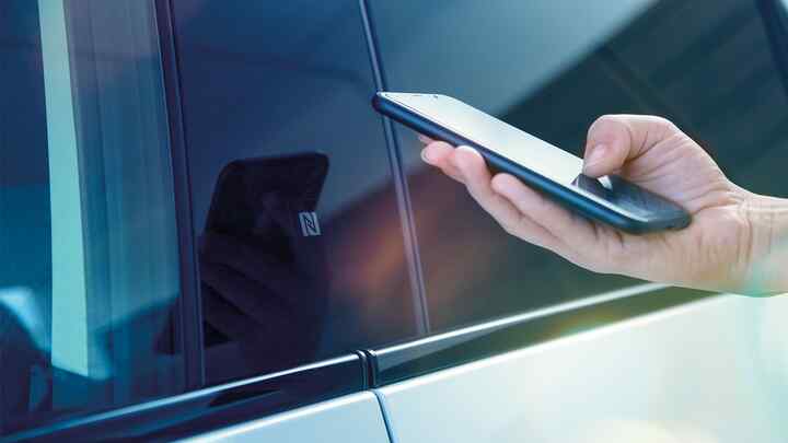 Detailní záběr aplikace My Honda+ na osobu používající smartphone mimo vozidlo